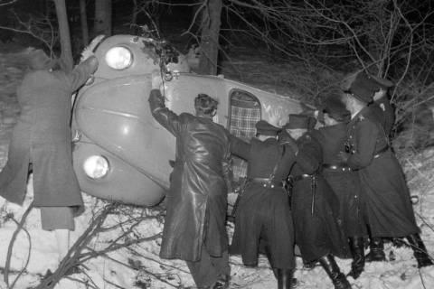 ARH NL Dierssen 1218/0014, Polizisten drehen einen auf dem Dach im Straßengraben liegenden VW-Käfer um, Steinkrug, 1952