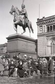 ARH NL Koberg 5030, Personen unterm Ernst-August-Denkmal (vermutlich Geflüchtete) vor dem Hauptbahnhof, Hannover, 1945