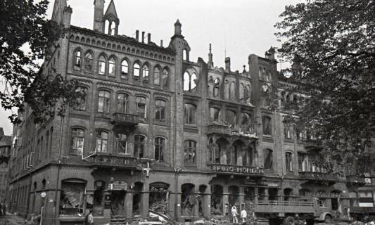 ARH NL Koberg 9425, Zerstörte Geschäfte, unter anderem "Foto Möhlen", "Erich Möller Rad" und "H. Döpke Gaststätte", (Zwangs?)Arbeiter verräumen Trümmer, Hannover, 1943