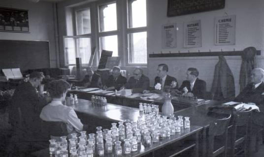 ARH NL Koberg 9670, Sechs Männer in Anzügen sitzen zwei jungen Personen in einem Lehrraum gegenüber, eventuell eine Prüfung, Hannover?, 1953