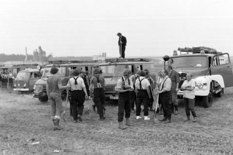ARH NL Mellin 01-131/0018, Männer mit Schaufeln vor einer Reihe von Kleinbussen der Feuerwehr Lüchow (Wendland)?, wohl 1976