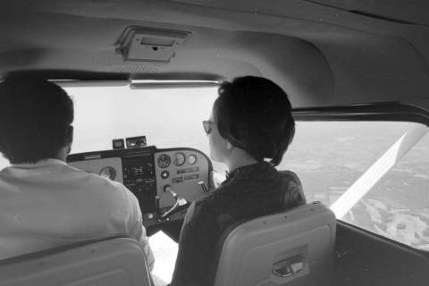 ARH NL Mellin 01-138/0001, Blick auf Pilot und "Beifahrerin" vom hinteren Sitz eines Flugzeugs in der Luft, ohne Datum