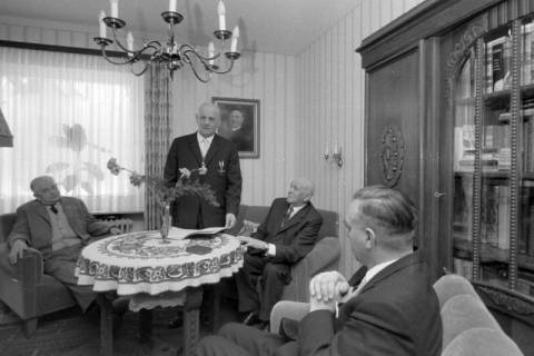 ARH NL Mellin 01-147/0018, Vier Männer in einem Wohnzimmer um einen Tisch sitzend, ohne Datum