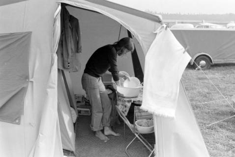 ARH NL Mellin 01-148/0018, Frau beim Geschirrspülen in einem Zelt, ohne Datum