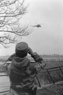 ARH NL Mellin 01-168/0016, Major des Bundesgrenzschutzes (BGS) in Sumpftarnuniform beobachtet einen russischen MI-2 Helikopter, nach 1972