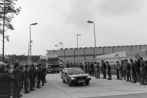 ARH NL Mellin 01-174/0011, Polizei und Presse vor dem Atommülllager von dessen Gelände PKWs und LKWs gefahren kommen, Gorleben, ohne Datum