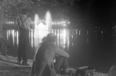 ARH NL Mellin 01-177/0007, Männer an einem Teich mit einem beleuchteten Springbrunnen in der Nacht, ohne Datum