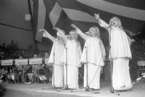 ARH NL Mellin 01-196/0014, Vier Sängerinnen auf einer Bühne in einem Festzelt, im Hintergrund die Band "Laura-Septett", ohne Datum