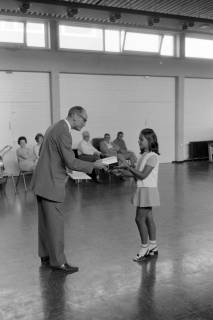 ARH NL Mellin 01-196/0016, Ehrung eines jungen Mädchens durch einen Herren in einer Sporthalle, ohne Datum