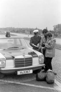 ARH NL Mellin  01-197/0008, Ein Polizist und zwei Zivilisten neben einem Polizeiwagen stehend und auf eine Karte schauend, ohne Datum