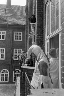 ARH NL Mellin 01-198/0006, Mann im Hofnarr(?)-Kostüm auf einem Balkon des Rathauses stehend und nach unten blickend, Lehrte, ohne Datum