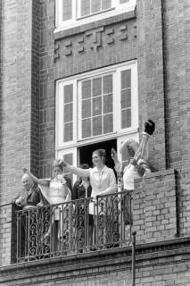 ARH NL Mellin 01-198/0008, Zwei Frauen und ein Mann im Hofnarr(?)-Kostüm auf dem Balkon des Rathauses stehend und nach unten blickend, Lehrte, ohne Datum