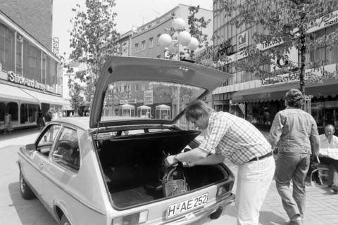 ARH NL Mellin 01-199/0015, Mann am Kofferraum eines Autos (Opel Kadett City) in der Osterstraße mit Blick in die Limburgstraße, Hannover Mitte, nach 1975