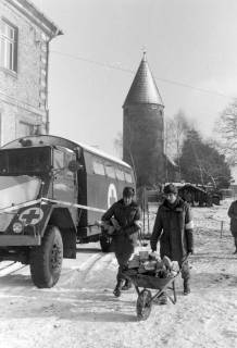 ARH NL Mellin 02-030/0016, Männer des Sanitätsdienstes mit Feuerholz in einer Schubkarre neben einem Krankenkraftwagen, ohne Datum