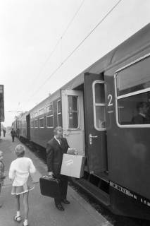 ARH NL Mellin 02-057/0018, Mann mit einem Paket vor der offenen Wagentür eines Zuges am Bahnsteig stehend, Burgdorf?, ohne Datum