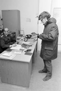 ARH NL Mellin 02-079/0019, Junger Mann bei einem Polizisten in einem Büro der Polizeiwache stehend, ohne Datum