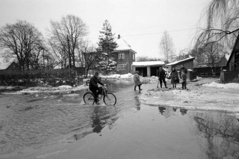 ARH NL Mellin 02-101/0004, Fahrradfahrer auf einer überschwemmten Straße im Winter, um 1970