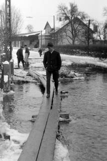 ARH NL Mellin 02-101/0005, Holzplanken zum Überqueren einer überschwemmten Straße im Winter, um 1970