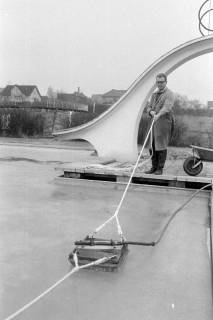 ARH NL Mellin 02-107/0010, Mann poliert(?) die Eisfläche im Becken eines Freibades, um 1970