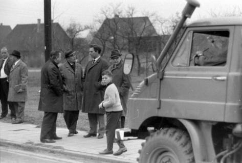 ARH NL Mellin 02-114/0013, Gruppe von Männern am Straßenrand stehend, um 1975