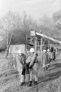 ARH NL Mellin 02-118/0005, Zwei Feuerwehrleute tragen eine Person von einem Brand weg, um 1975