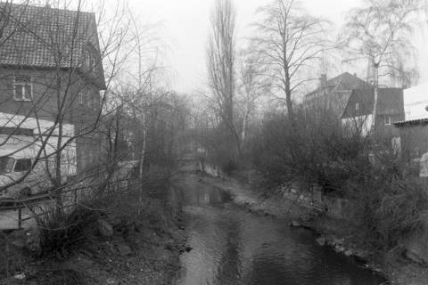 ARH NL Mellin 02-123/0013, Blick von einer Brücke auf einen Fluss in einer Stadt, um 1975