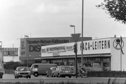 ARH NL Mellin 02-125/0004, Blick auf Gebäude von "HACA-Leitern", einem "Tapeten-Farben-Fußboden Discount" und "Siemens" im Industriegebiet, Altwarmbüchen, um 1975