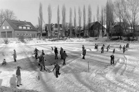 ARH NL Mellin 02-129/0001, Personen befreien eine Eisfläche vom Schnee und laufen Schlittschuh, um 1975