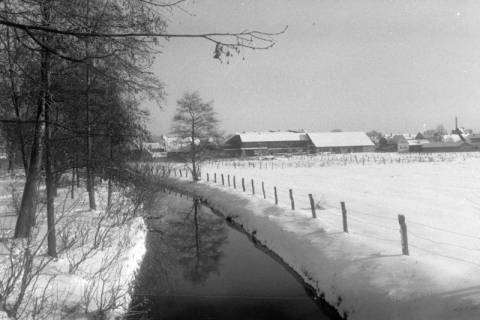 ARH NL Mellin 02-133/0009, Blick von der Brücke am "Alter Jagdsteg" auf die Aue und den verschneiten Ort, Burgdorf, um 1975