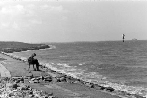 ARH NL Mellin 02-141/0002, Eine Person am Meer sitzend, rechts ein Leuchtfeuer, um 1975