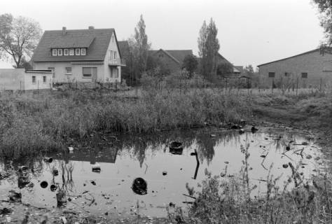 ARH NL Mellin 02-167/0012, Müll in einem Teich in einem Dorf, um 1975