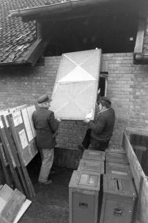ARH NL Mellin 02-182/0006, Zwei Männer beim Heben einer Trennwand(?) für Wahlen, um 1970