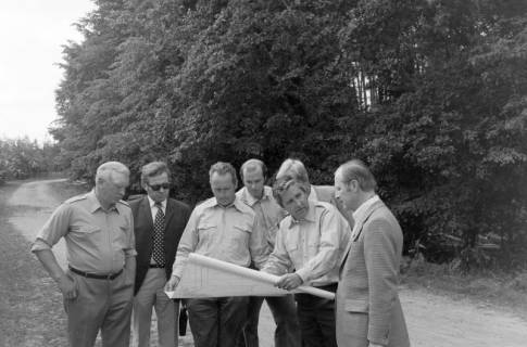 ARH NL Mellin 02-188/0011, Gruppe von Männern mit einer Karte auf einem Weg an einem Wald stehend, um 1970