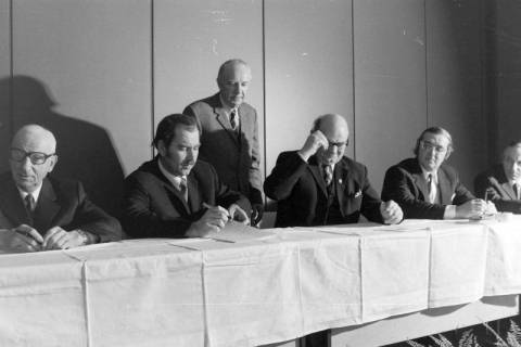 ARH NL Mellin 02-192/0016, Männer unterzeichnen ein Dokument bei einer Versammlung, um 1970