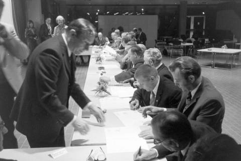 ARH NL Mellin 02-194/0017, Männer unterzeichnen Dokumente bei einer Versammlung, um 1970