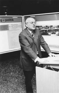 ARH Slg. Bartling 153, Günter Leddin, Vorsitzender des Großraumverbandes, am Rednerpult stehend vor Stellwänden mit Exponaten zum Verband, um 1975