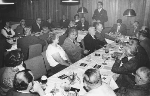 ARH Slg. Bartling 342, Stadtdirektor Felix Rohde, stehend, einen Vortrag haltend vor Männern und Frauen, die an Tischen im Hotel Scheve sitzen, 1971