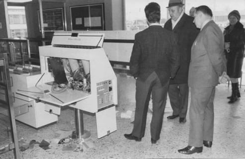 ARH Slg. Bartling 408, Drei Männer begutachten den von Einbrechern zerstörten Automaten im Eingangsbereich des Hallenbades, 1972