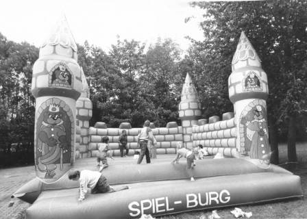 ARH Slg. Bartling 434, Spiel-Burg (Hüpfburg) mit spielenden Kindern im Park des Freibads, um 1980