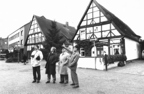 ARH Slg. Bartling 548, Giebel der beiden Fachwerkhäuser in der Windmühlenstraße 19 und 20, davor vier Männer, die das gegenüberliegende Haus am Hufeisenweg begutachten, um 1980