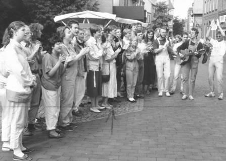 ARH Slg. Bartling 814, Musikalische Einlage eines singenden Gittaristen mitsamt applaudierenden Zuhörern auf der Marktstraße, Neustadt a. Rbge., um 1980