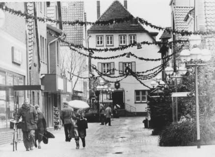 ARH Slg. Bartling 957, Windmühlenstraße 28, Blick durch die vorweihnachtlich geschmückte Straße auf das Diakoniehaus / Kirchenkreisamt, Marktstraße 35, Neustadt a. Rbge., um 1975
