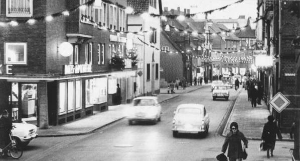 ARH Slg. Bartling 960, Marktstraße 5, Blick in die abendliche, viel befahrene, vorweihnachtlich geschmückte Straße nach Westen auf die südlichen Häuserfronten, Neustadt a. Rbge., 1973