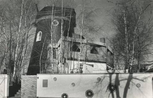 ARH Slg. Bartling 1014, Holländerwindmühle mit vorgebautem modernen Wohnhaus in der Wintersonne, Neustadt a. Rbge., 1975