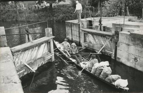 ARH Slg. Bartling 1026, Schleusenwärter Ferlemann läßt ein Ruderboot, besetzt mit drei Personen und beladen mit fünf Säcken durch das geöffnete Schleusentor in die Schleuse einfahren, Neustadt a. Rbge., 1974