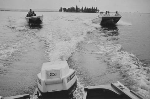 ARH Slg. Bartling 1175, Nordufer, Blick vom Heck eines Bootes (mit Außenbordmotor) auf zwei nachfolgende Motorboote, im Hintergrund die Insel Wilhelmstein, Steinhuder Meer, 1970
