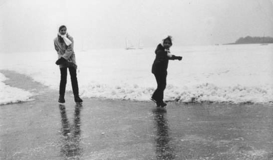 ARH Slg. Bartling 1188, Nordufer, 2 Schlittschuhläufer hintereinander auf einer vom Schnee geräumten Eisbahn des zugefrorenen, verschneiten Sees, Steinhuder Meer, um 1969