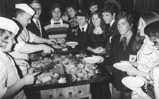 ARH Slg. Bartling 1283, Jugendliche umringen den Metzger und seine Bratpfannen beim Essen-Fassen im Therapiezentrum des DRK, Mardorf, 1973