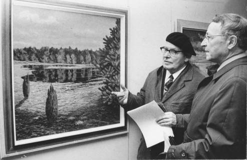 ARH Slg. Bartling 1342, Der Kunstmaler Paul Smalian, Steinhude, (1901-1974) stellt sein Gemälde mit einem flachen See im Wald (Bannsee?) einem Mann vor, Neustadt a. Rbge., 1973