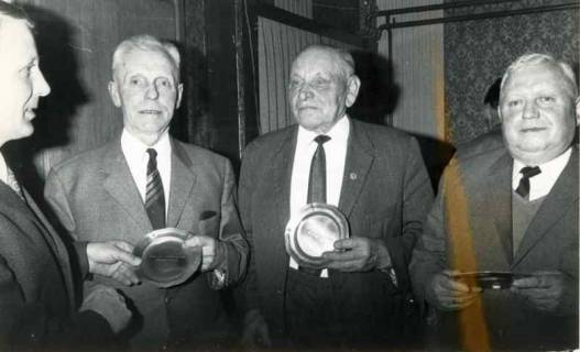 ARH Slg. Bartling 1377, Überreichung eines Zinntellers an drei nebeneinander stehende ältere Herren durch N. N. von der Spar- und Darlehnskasse Helstorf-Mandelsloh, 1972